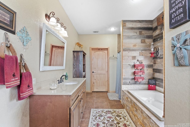 bathroom featuring a relaxing tiled tub, tile patterned floors, and vanity