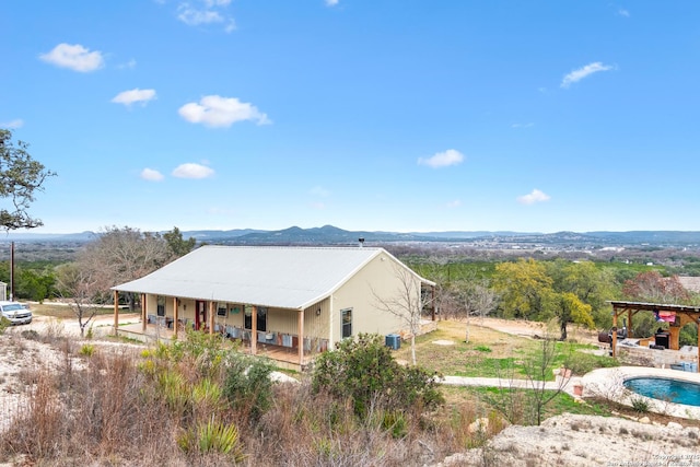 exterior space featuring central AC unit, a fireplace, and a mountain view