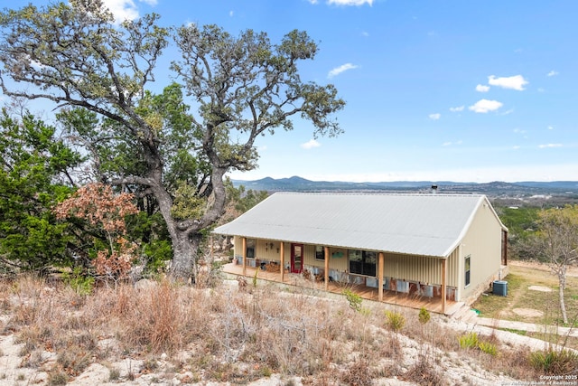 exterior space with a porch, a mountain view, and central air condition unit