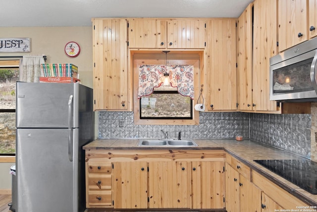 kitchen with sink, tile countertops, a healthy amount of sunlight, and appliances with stainless steel finishes