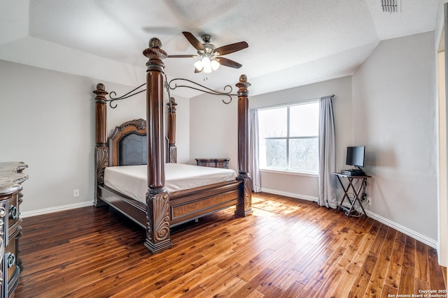 bedroom with ceiling fan, dark wood-type flooring, a textured ceiling, and vaulted ceiling