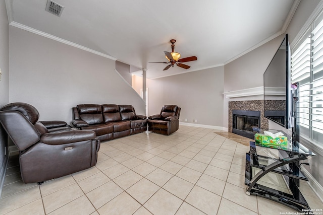 living room featuring light tile patterned flooring, ceiling fan, plenty of natural light, and a fireplace