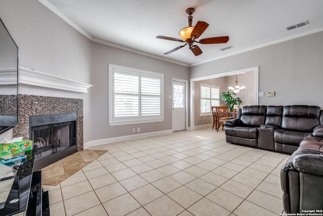 tiled living room with a tiled fireplace, ceiling fan with notable chandelier, and ornamental molding