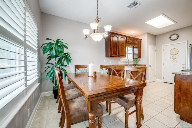 dining room with a chandelier, sink, and light tile patterned floors