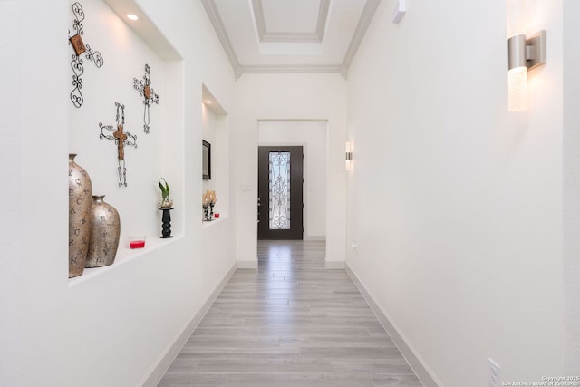 hall with ornamental molding and light hardwood / wood-style flooring