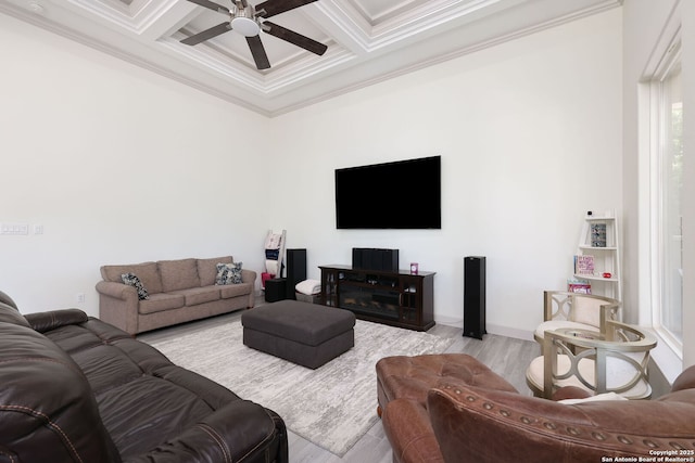 living room featuring beamed ceiling, coffered ceiling, ceiling fan, crown molding, and light wood-type flooring