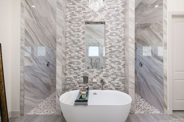 bathroom featuring shower with separate bathtub and tile walls