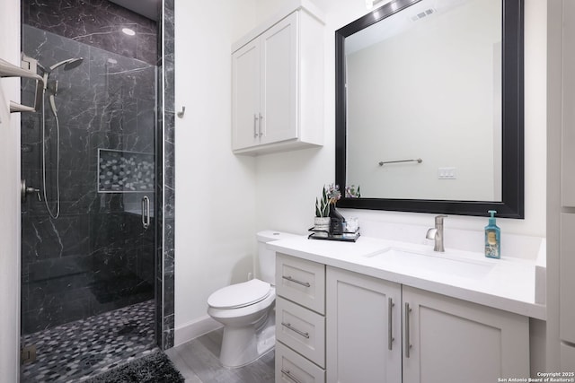 bathroom with vanity, hardwood / wood-style floors, a shower with shower door, and toilet