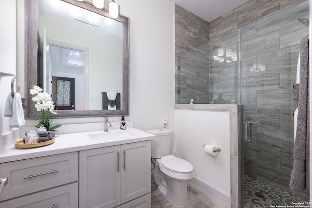 bathroom with walk in shower, vanity, and toilet