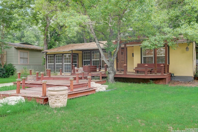 view of front facade featuring a wooden deck, a sunroom, and a front lawn