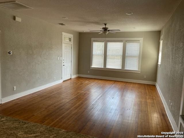 spare room featuring wood-type flooring and ceiling fan