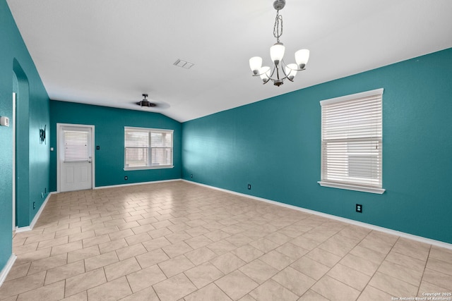 unfurnished room featuring lofted ceiling and ceiling fan with notable chandelier