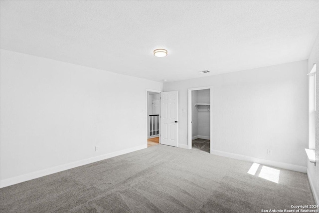 unfurnished bedroom featuring light carpet and a textured ceiling