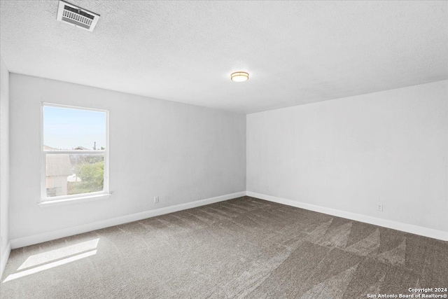 carpeted spare room with a textured ceiling