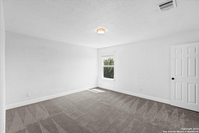 unfurnished room with a textured ceiling and carpet