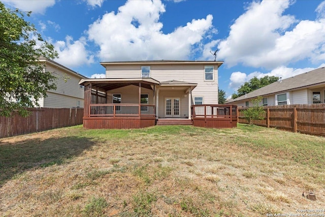 rear view of property featuring a yard and a deck