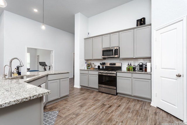 25046 Las Pilas, San Antonio, TX 78261 - kitchen featuring sink, decorative light fixtures, gray cabinets, stainless steel appliances, and light stone countertops