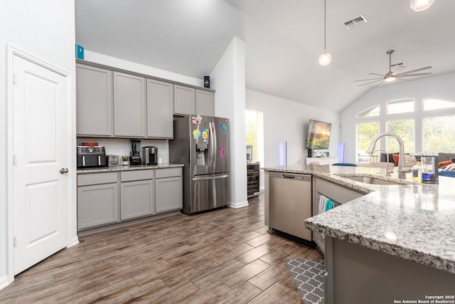 25046 Las Pilas, San Antonio, TX 78261 - kitchen featuring gray cabinets, appliances with stainless steel finishes, decorative light fixtures, sink, and light stone counters