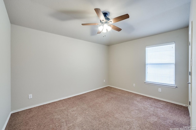 unfurnished room with ceiling fan and carpet