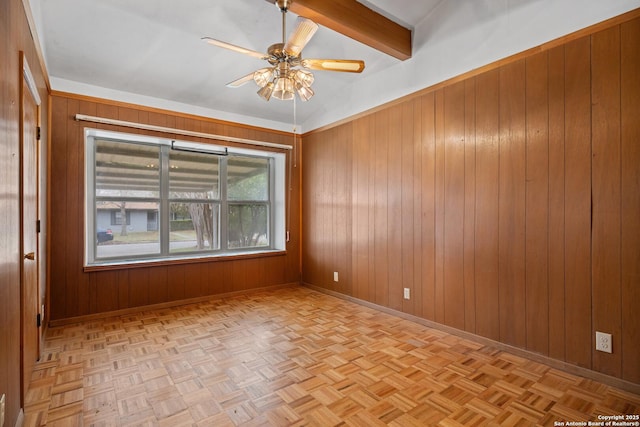 unfurnished room with ceiling fan, lofted ceiling with beams, light parquet flooring, and wood walls