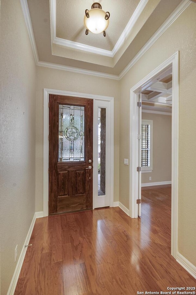 entrance foyer with hardwood / wood-style floors, ornamental molding, coffered ceiling, a tray ceiling, and beam ceiling