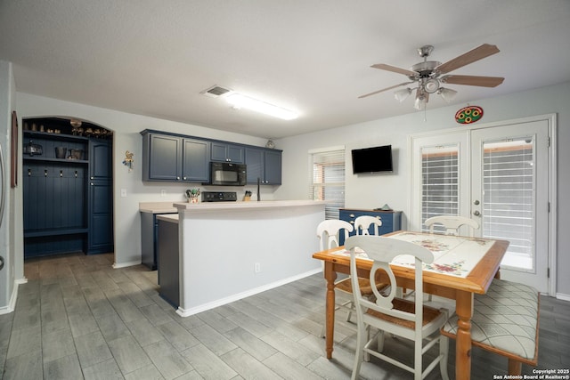 kitchen featuring stove, dark wood-type flooring, french doors, and ceiling fan