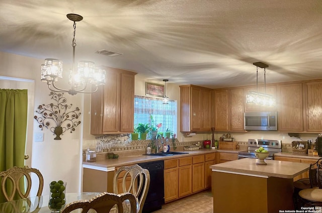 kitchen featuring sink, appliances with stainless steel finishes, a center island, decorative light fixtures, and a chandelier