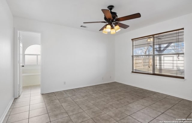 tiled spare room with ceiling fan