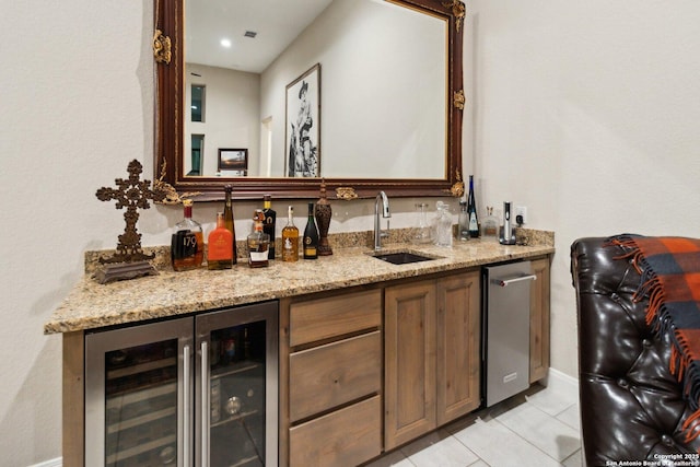 bar featuring wine cooler, sink, light stone counters, and light tile patterned floors