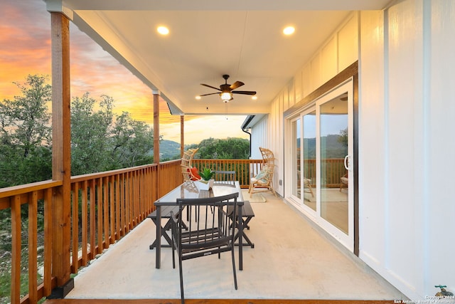 deck at dusk featuring ceiling fan