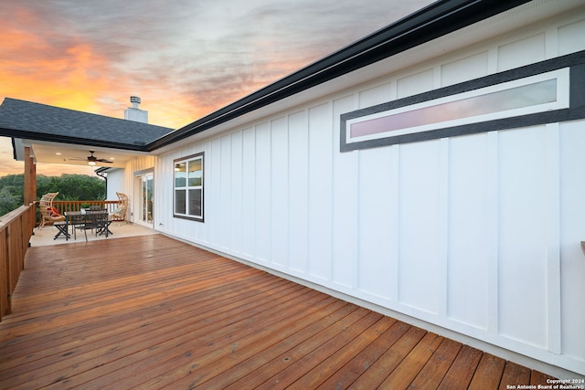 deck at dusk featuring ceiling fan