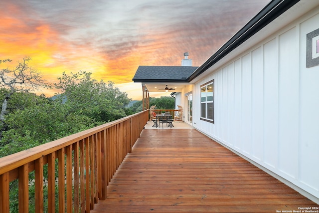 deck at dusk featuring ceiling fan