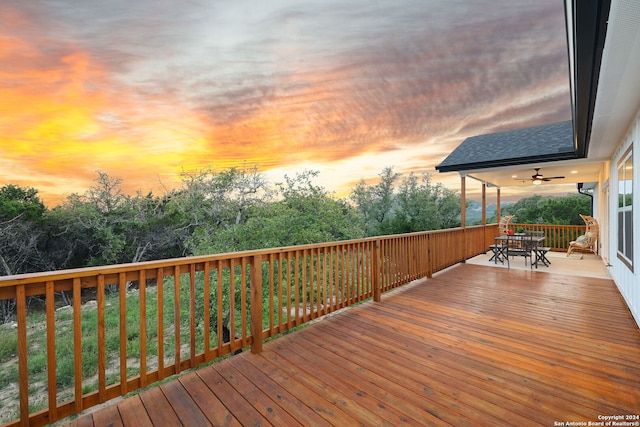 deck at dusk featuring ceiling fan