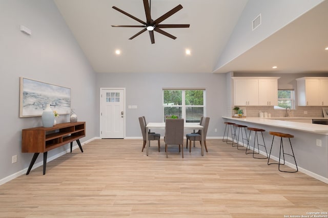 dining area featuring a healthy amount of sunlight, sink, and light hardwood / wood-style floors