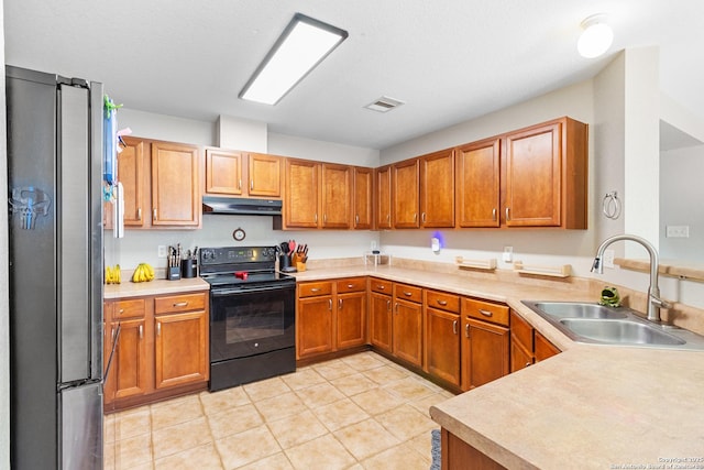 kitchen with visible vents, freestanding refrigerator, under cabinet range hood, black range with electric cooktop, and a sink