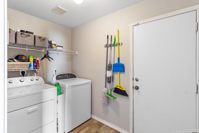 laundry area featuring light wood-style flooring, laundry area, visible vents, baseboards, and washer and dryer