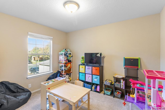 recreation room featuring a textured ceiling and carpet flooring