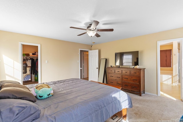 bedroom with baseboards, ceiling fan, carpet, a spacious closet, and a closet