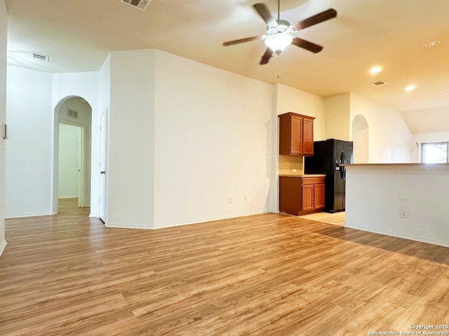 unfurnished living room with ceiling fan, lofted ceiling, and light hardwood / wood-style floors