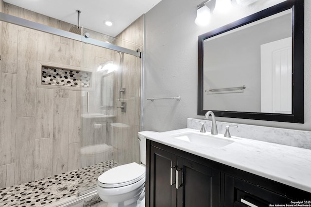 bathroom featuring vanity, toilet, and walk in shower