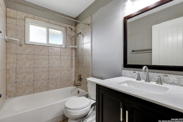 full bathroom with tiled shower / bath, vanity, and toilet