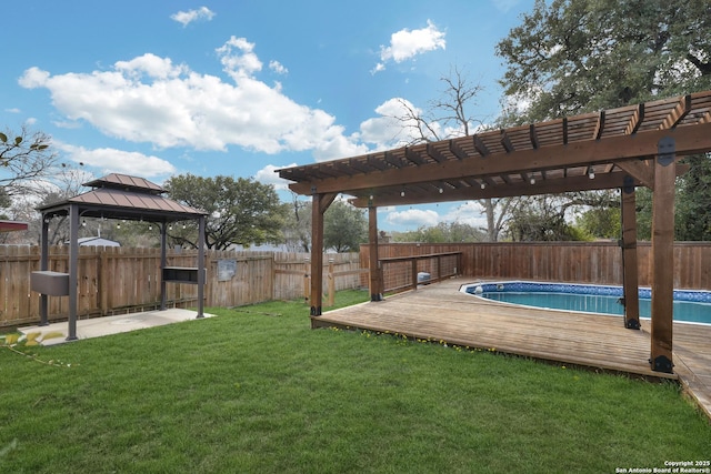 view of pool with a gazebo, a wooden deck, and a lawn