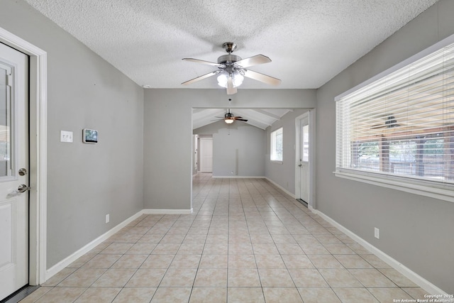 interior space featuring ceiling fan, lofted ceiling, and a textured ceiling