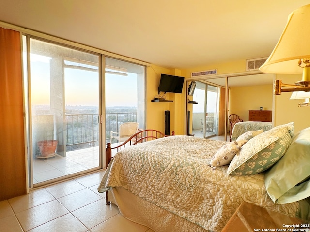 bedroom with expansive windows, access to outside, and tile patterned floors