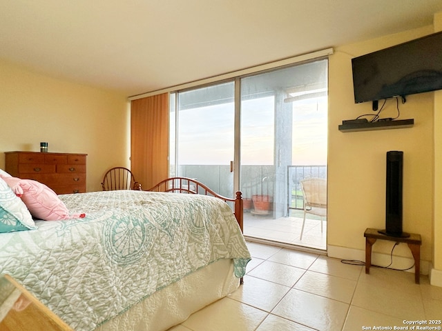 bedroom featuring tile patterned flooring, access to outside, and a wall of windows