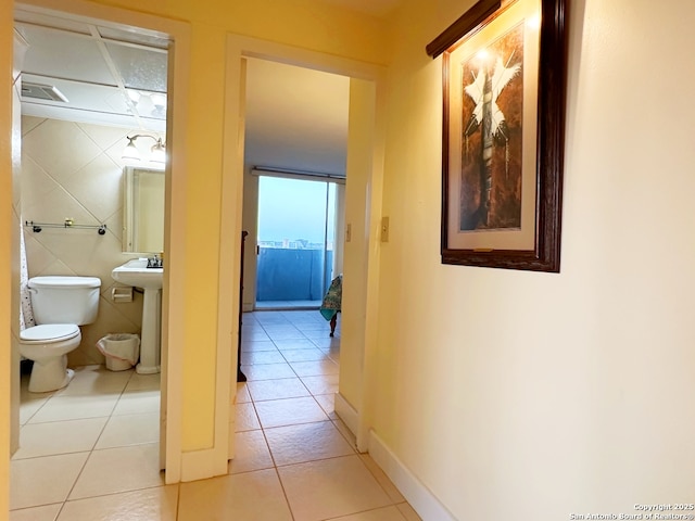 hallway featuring light tile patterned floors and sink