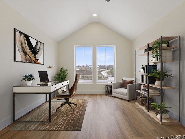 office space featuring vaulted ceiling and light hardwood / wood-style flooring