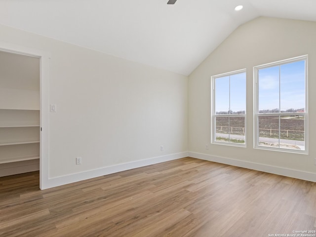 spare room featuring lofted ceiling, light hardwood / wood-style flooring, and ceiling fan