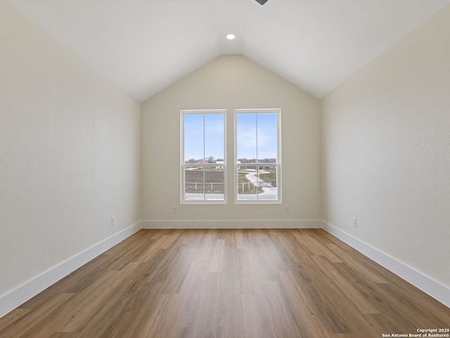 bonus room with hardwood / wood-style flooring and vaulted ceiling