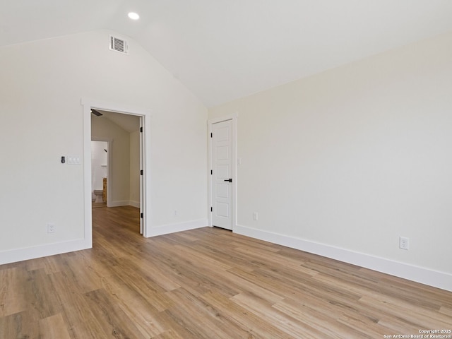 unfurnished room featuring vaulted ceiling and light wood-type flooring